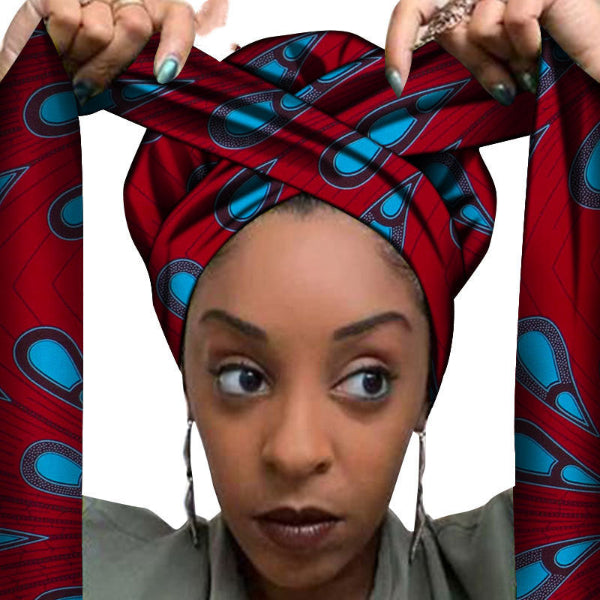 Woman wearing a red and blue patterned headscarf with hands holding it on a white background