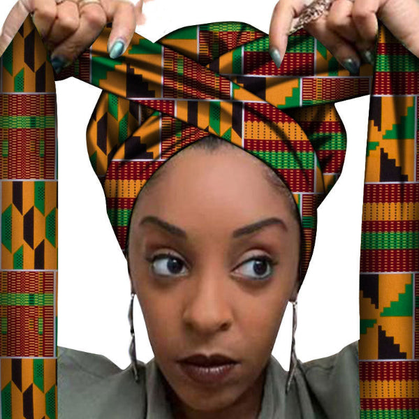 Woman wearing a colorful Kente headwrap with hands holding it on a white background