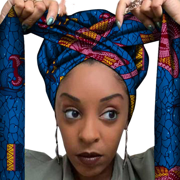 Woman wearing a colorful headscarf with intricate patterns, set against a white background.