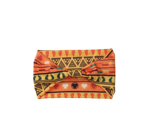 Orange and yellow patterned headband with a bow on a white background